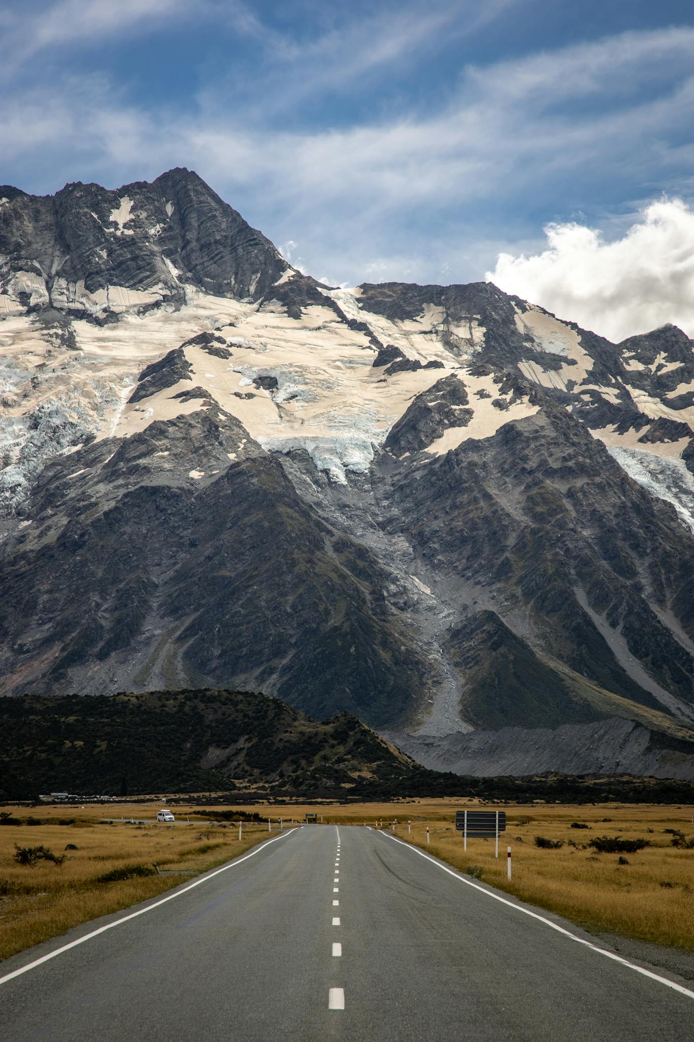 Road among grassland leading to mountains